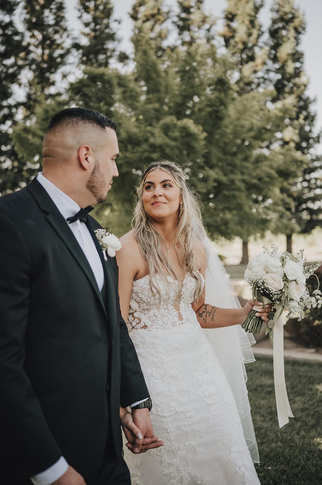 The bride looking at her groom, bouquet in hand