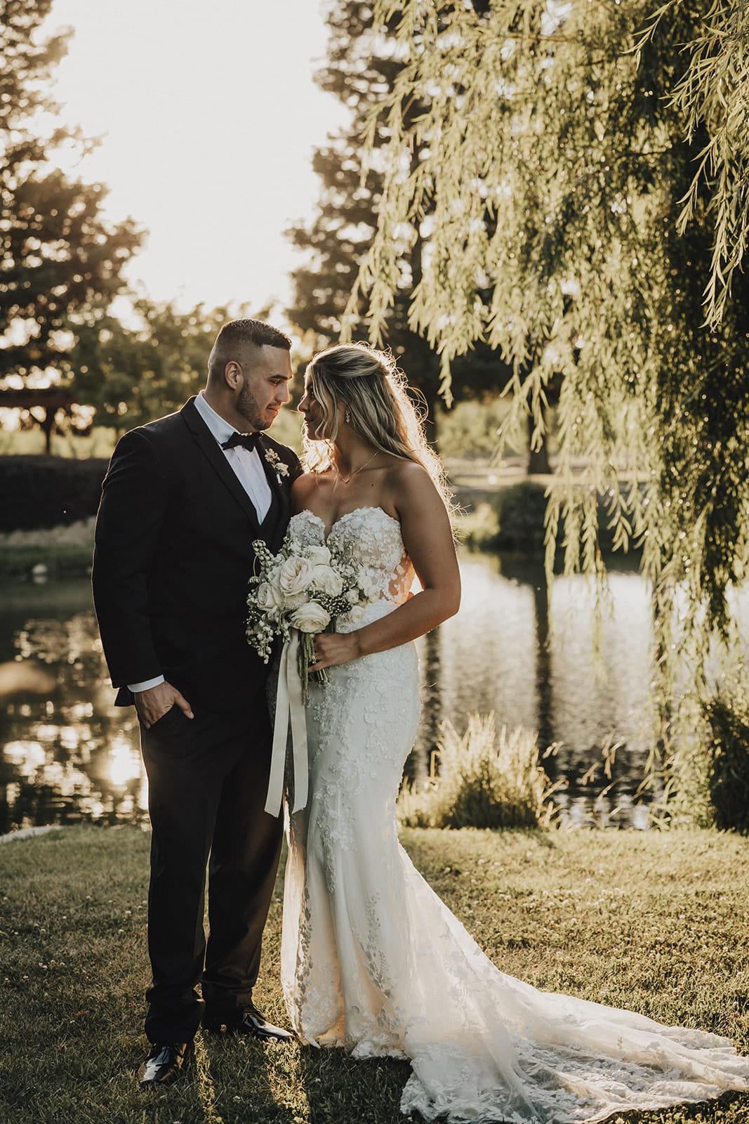 The couple by the pond under the willow at golden hour