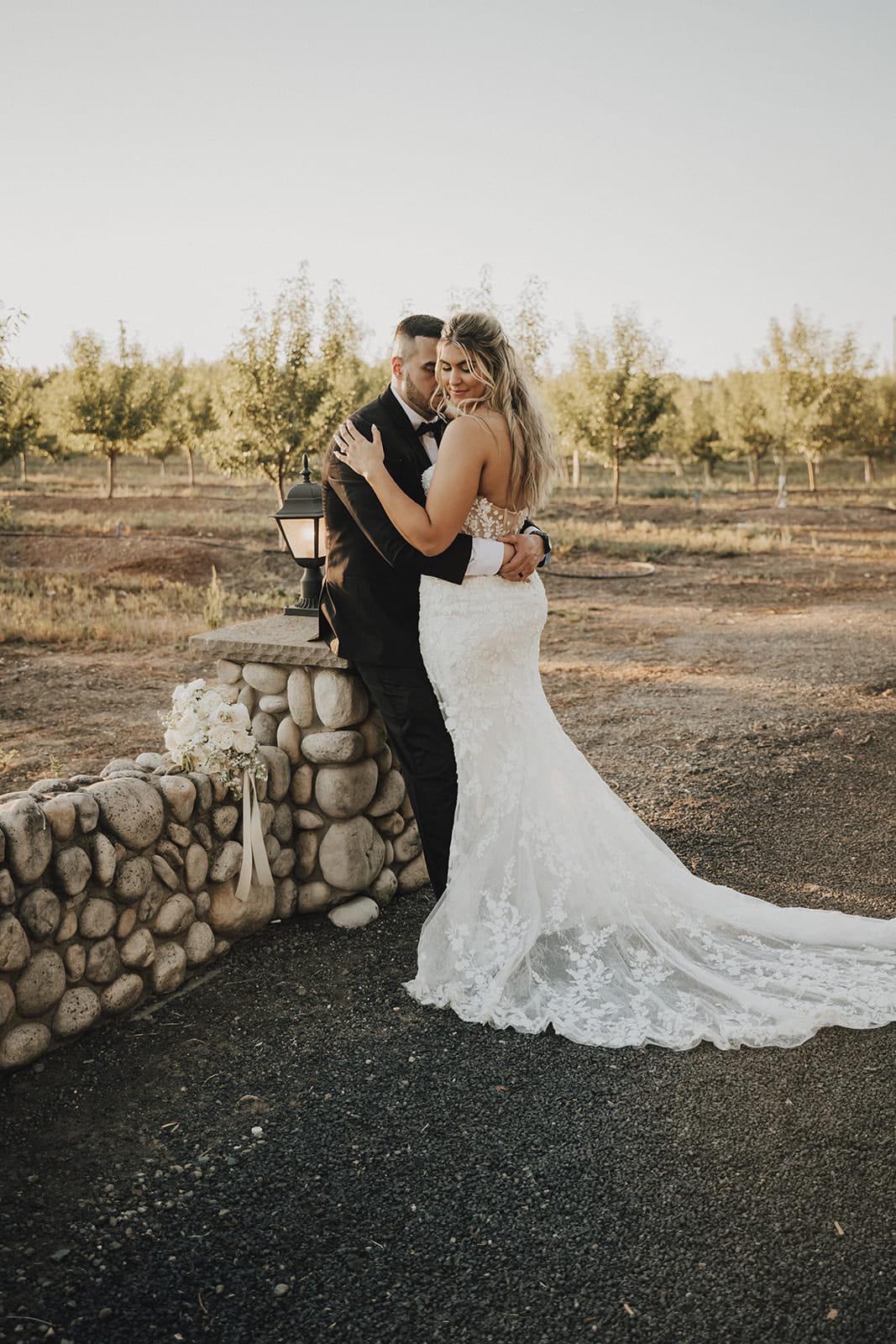 The couple embracing beside the stone wall and lantern