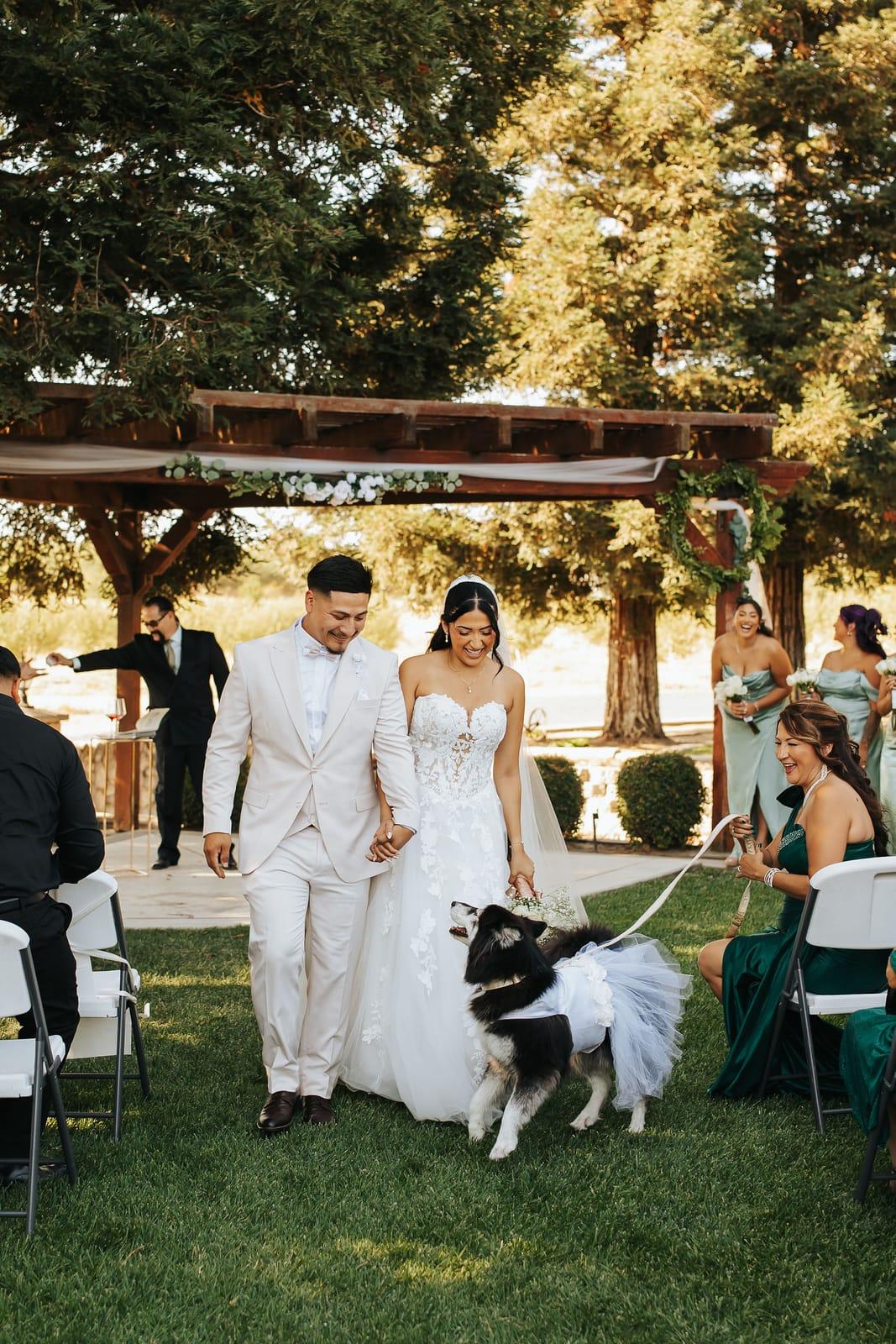 Back up the aisle as newlyweds, their dog leading the way in a tutu