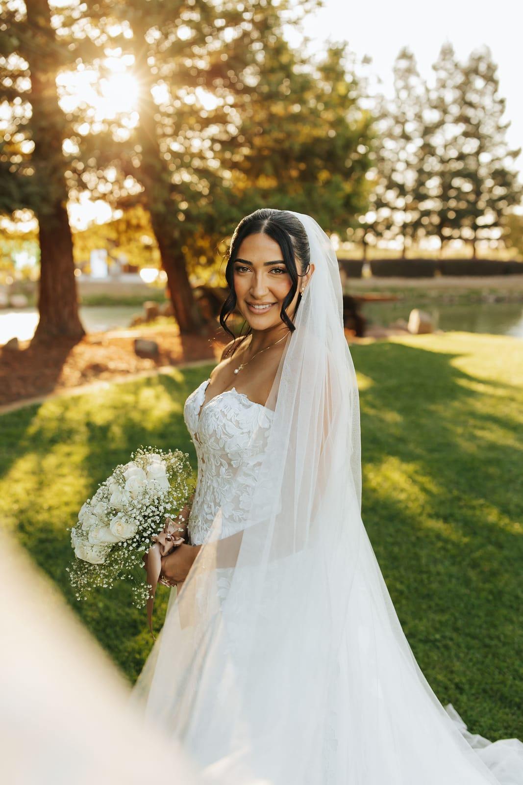 The bride with her bouquet, golden light through her veil