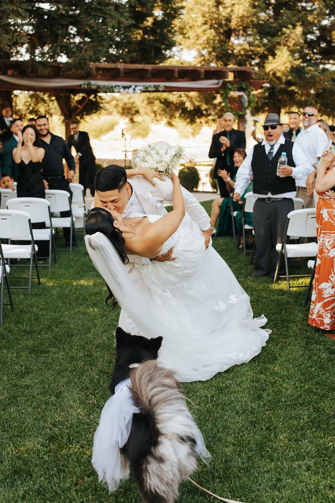A dip kiss in the aisle as the guests cheer