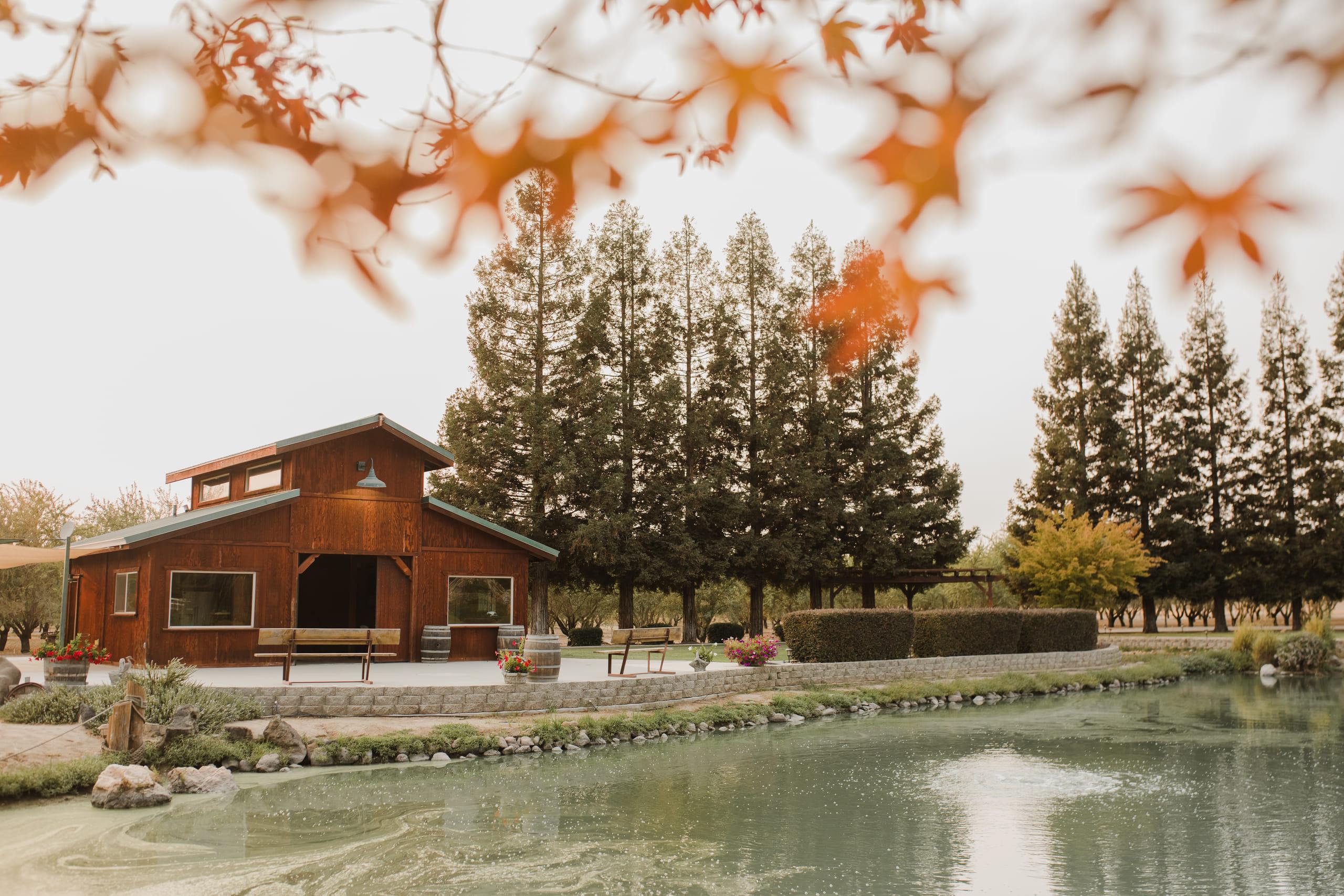 The barn mirrored in the pond, framed by autumn maple leaves